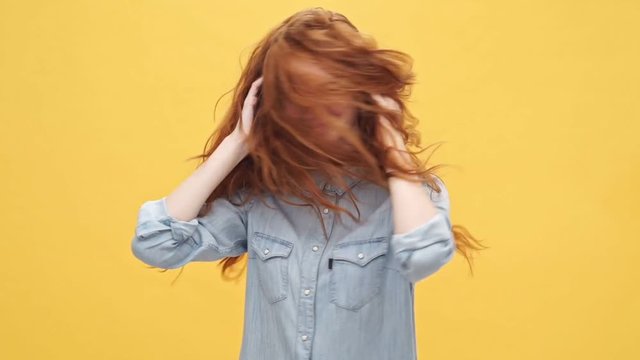 Screaming upset ginger woman in denim shirt refuses to agree with something over yellow background