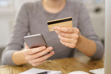 frau mit kreditkarte und mobiltelefon