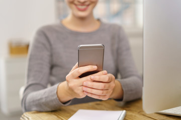 lächelnde frau liest nachrichten am mobiltelefon