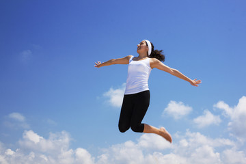 Fototapeta premium happy young woman jumping in the air