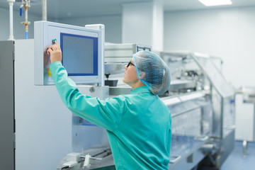 operator in the pharmaceutical factory near the equipment