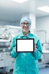 pharmaceutical factory worker with a tablet in his hands shows Equipment