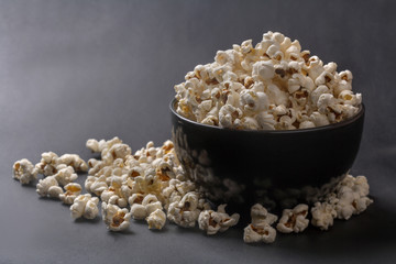 Freshly prepared popcorn in a bowl on a black background