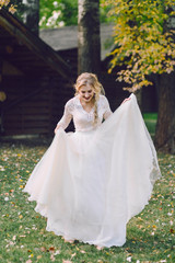 Obraz na płótnie Canvas Happy bride is posing in fluttering dress on nature. Artwork