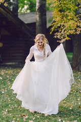 Happy bride is posing in fluttering dress on nature. Artwork