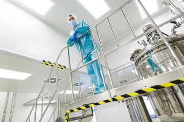plant picture, scientist standing on ladder, crossed hands