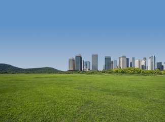 Obraz premium green lawn with city skyline background, tianjin china.