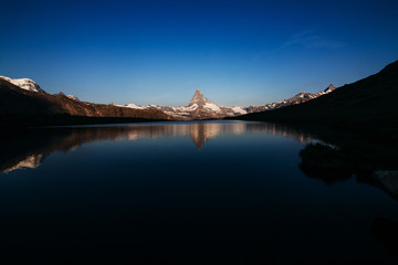 morning mountain matterhorn with a lake in shadow. Switzerland Zermatt