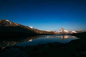 morning mountain matterhorn with a lake in shadow. Switzerland Zermatt