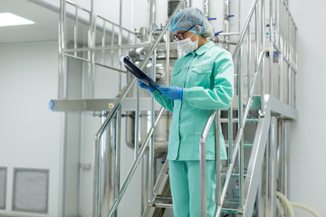 plant picture, scientist standing on steel stairs with tablet
