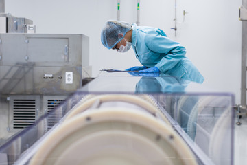 factory worker stand near machine with tablet, bended