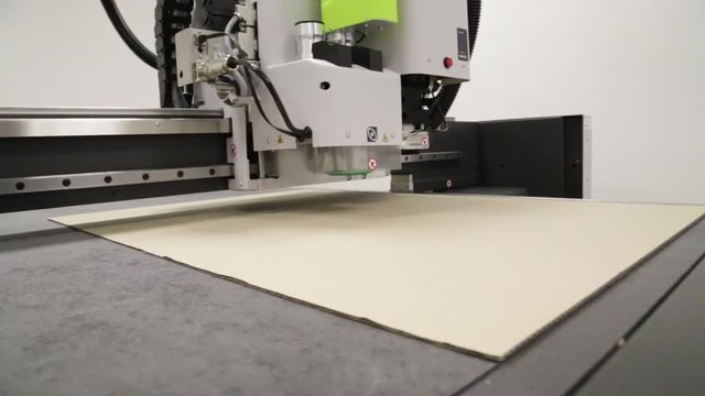 Robot paper cutter is cutting cardboard