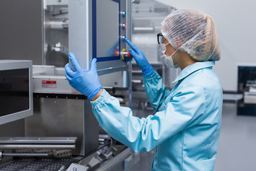 factory worker configures control panel