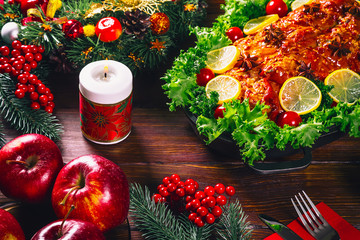 Thanksgiving table served with  baked meats, decorated with bright Christmas decor and candles. Christmas dinner with roasted pork meat. The concept of a family holiday, delicious food