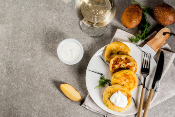 Vegan food. Cheese mashed potato pancakes, cutlets with dill and sour cream. On gray stone background, copy space top view