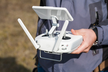 Man holds a drone remote controller in his hands. Close-up of quadrocopter RC during flight. Pilot takes aerial photos and videos with quad