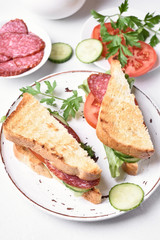 Club sandwiches with salami, tomatoes, cucumber