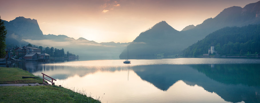 Misty morning panorama of Grundlsee lake. Beautiful summer view of Gessl village, Liezen District of Styria, Austria, Alps. Europe. Artistic style post processed photo.