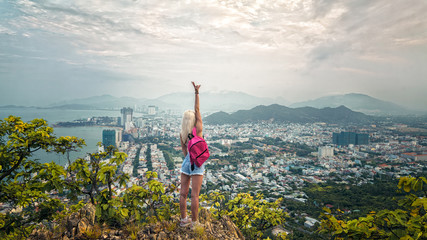 девушка блондинка на горе с видом на город