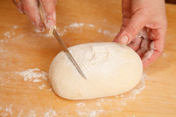 Hands cutting bread dough