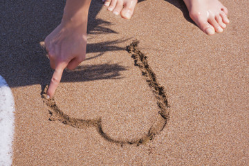 Drawing heart on the sand