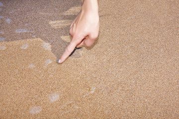 Hand writing in sand
