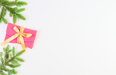 Christmas background. Christmas tree branch and present with gold ribbon on white background