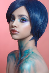 Fashion beauty portrait of a beautiful girl with bright creative make-up and blue hair.