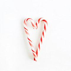 Heart made of Christmas candies on white background. Flat lay, top view.