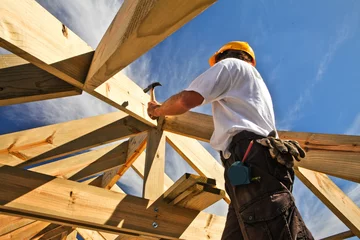 Fotobehang roofer ,carpenter working on roof structure at construction site © sculpies