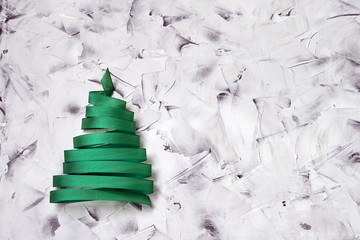 Christmas tree made from green ribbon on colorful  background. Copy space