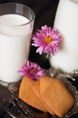 a glass of milk. a glass bottle of milk. wooden background. biscuit