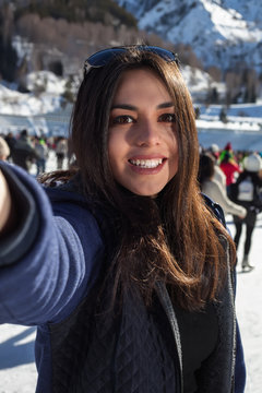 Beautiful woman on skates taking a selfie . the mountains in the background