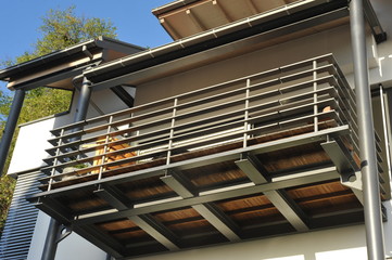 Stahl-Balkon mit Überdachung an moderner Hausfront - obrazy, fototapety, plakaty