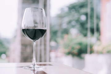 Glass of red wine on table in restaurant with tone color.