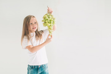 Girl holding grape, close up. concept. isolated on white. Nerd is wearing glasses. Child isolated on white background