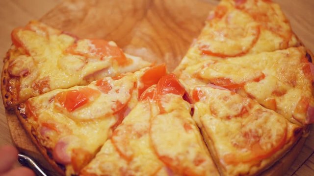 Hands taking slices of pizza