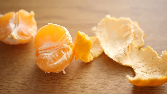 A half of tangerine with peel on the table 