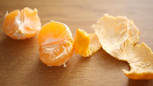 Little girl taking a half of tangerine