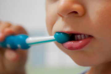 Bambino lava i denti con uno spazzolino