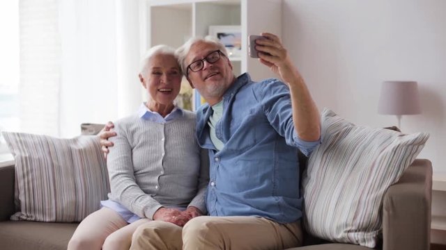 happy senior couple with smartphone at home
