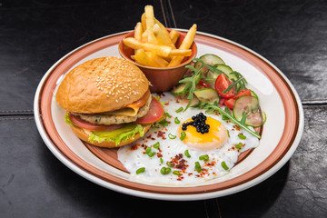 eggs, burger and french fries at plate