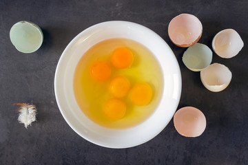 Fresh eggs in a white bowl. Concept of organic products. Farm. Broken eggs with bright yolks.