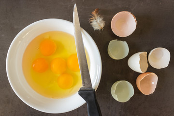 Fresh eggs in a white bowl. Concept of organic products. Farm. Broken eggs with bright yolks.