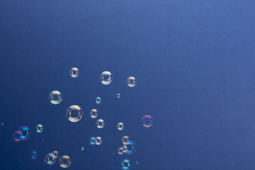 Rising Soap Bubbles Over Blue Background