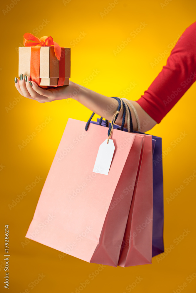 Wall mural female hand holding bright shopping bags