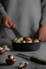 Mushrooms in vintage pan on gray wooden background