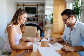 Happy couple having fun drawing at home