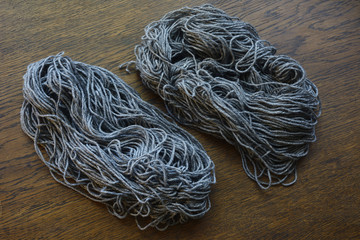 coils of gray wool on a wooden table
