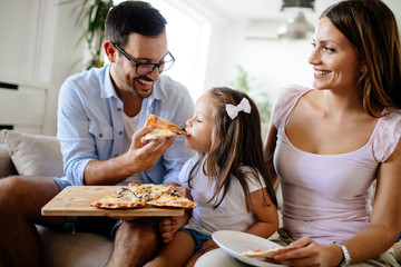 Happy family sharing pizza together at home
